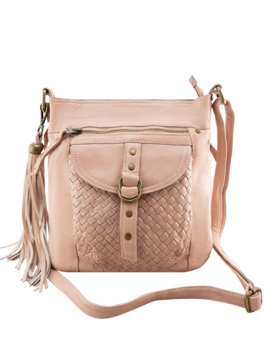 Millie Misty Rose leather crossbody bag with a woven front pocket, brass-tone hardware, a front zipper, and a tassel charm, shown on a plain white background.