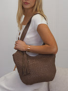  Truffle brown woven leather front shoulder bag with detachable  tassel detail. 
