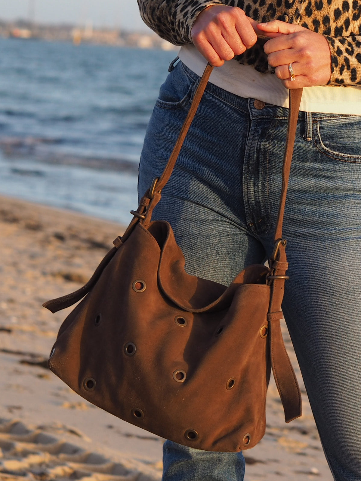 Cadelle Stevie chocolate suede shoulder bag with metal eyelets and an adjustable strap
