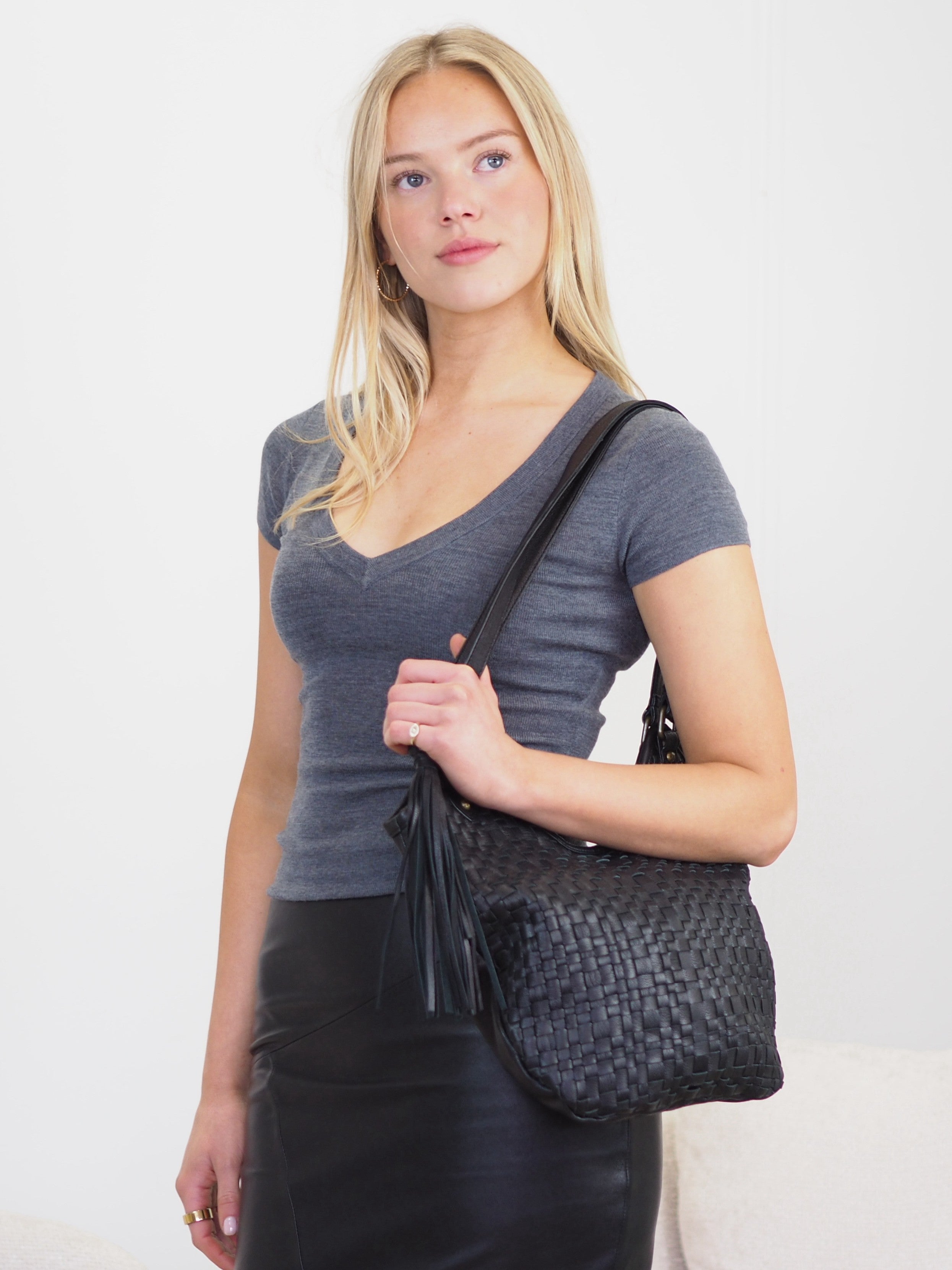 Jada black leather shoulder bag with woven front, double handles and detachable tassel